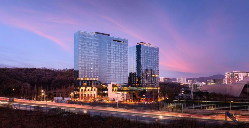 a city skyline at night with a rainbow in the sky at DoubleTree By Hilton Seoul Pangyo Residences in Seongnam