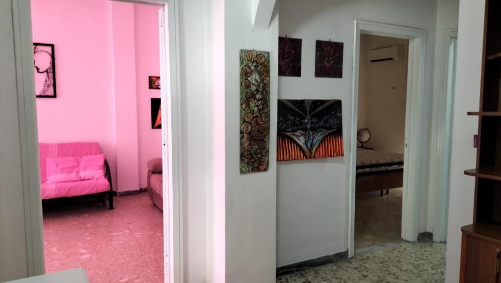 um quarto rosa com um sofá rosa e um espelho em Casa Vacanza Casale em Brindisi
