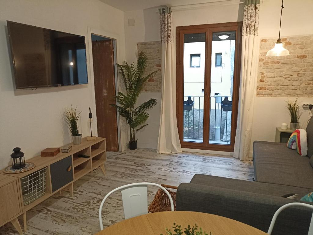 een woonkamer met een bank en een tafel bij Petra apartments -Old City with terrace and barbecue- in Tarragona
