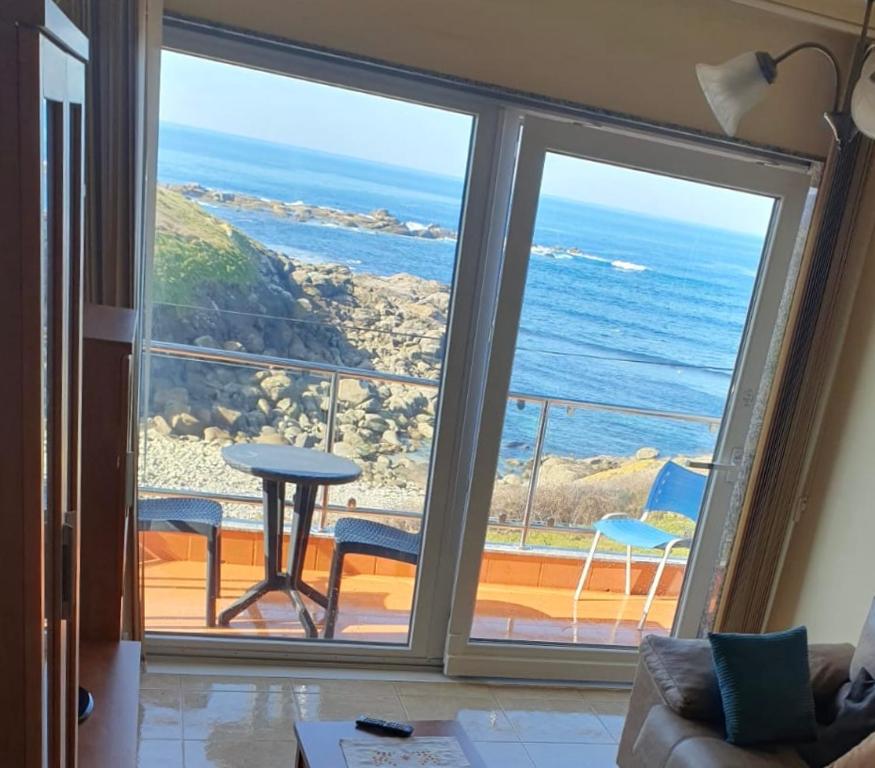 Una sala de estar con vista al mar. en Beiramar, en Muxía
