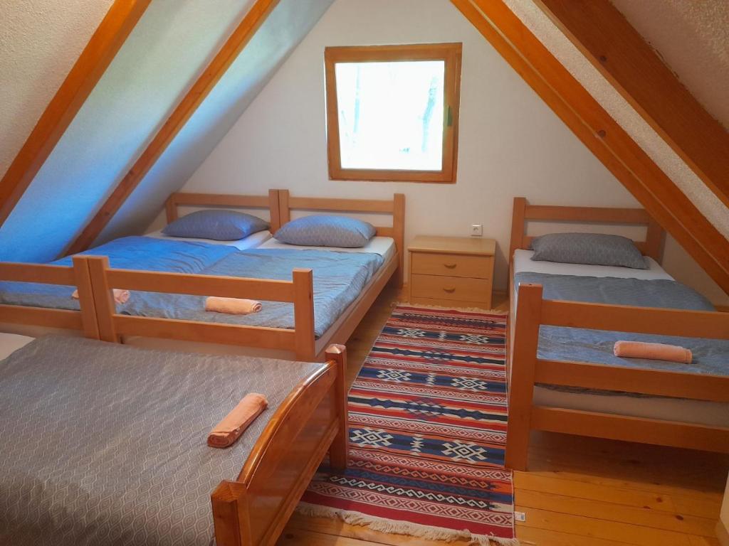 a attic bedroom with two beds and a window at Pure Nature in Bihać