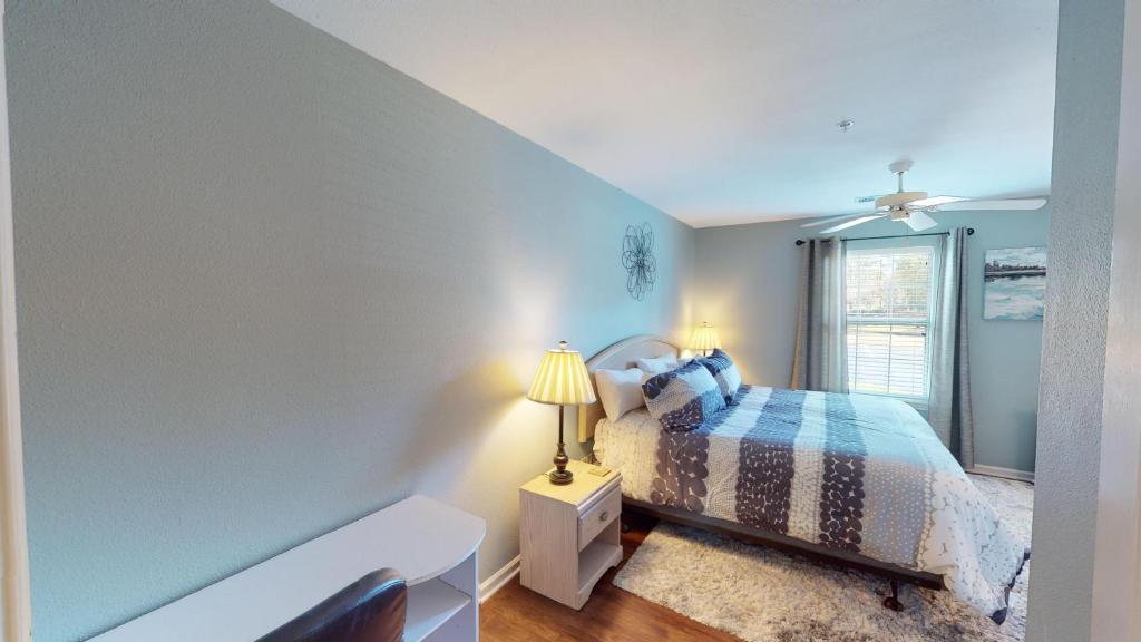 a bedroom with a bed with a lamp and a window at Golf Course Oasis Inviting 3BRVilla Pawleys Island in Pawleys Island