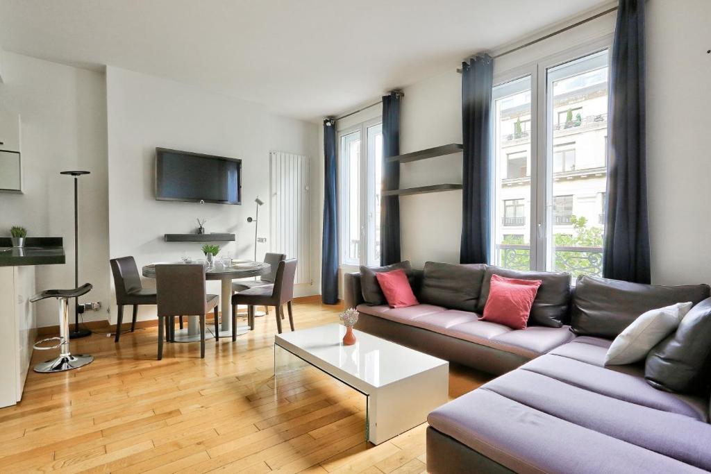 ein Wohnzimmer mit einem Sofa und einem Tisch in der Unterkunft Appartement Quartier Champs-Élysées 4 in Paris