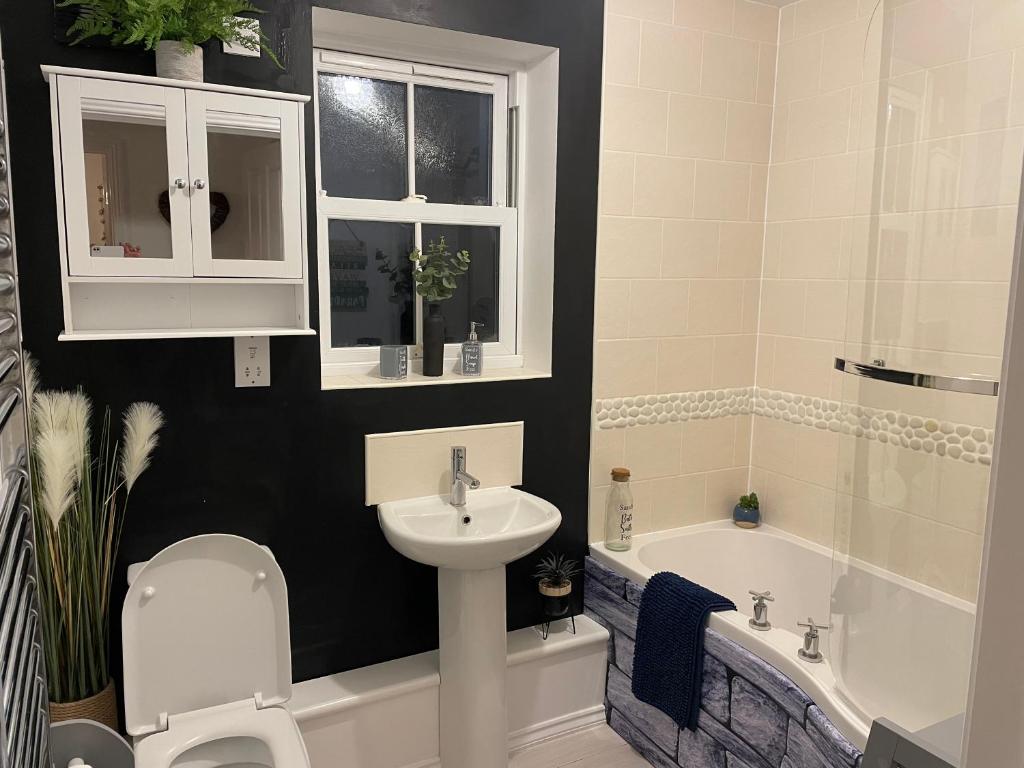 a bathroom with a sink and a toilet and a bath tub at Sandy Feet in Filey