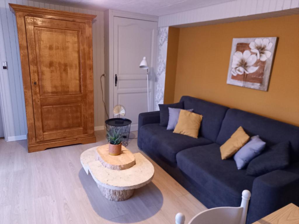un salon avec un canapé bleu et une table dans l'établissement La Croix de la Roche, à Trémuson