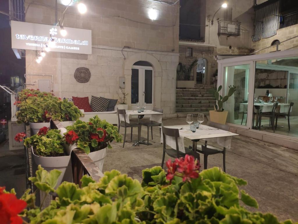 Minervino MurgeにあるTaverna Garibaldi Casa Luciaのテーブルと椅子、植物のあるレストラン