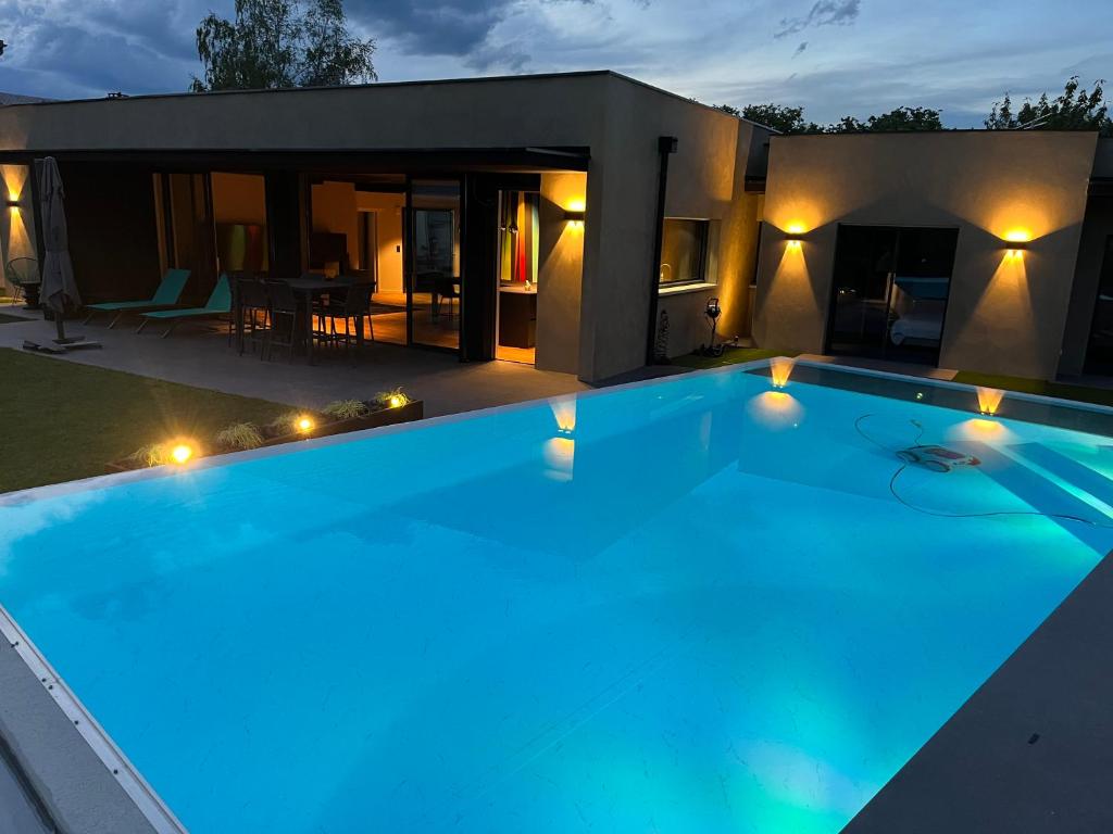 a large swimming pool in front of a house at La Villa Cosy in Espalion