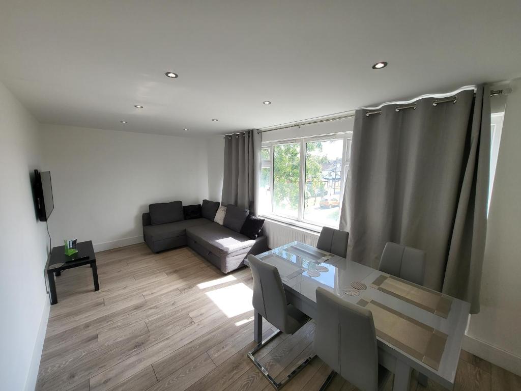 uma sala de estar com uma mesa e um sofá em Bright Modern 3 Bedroom Apartment em Sutton