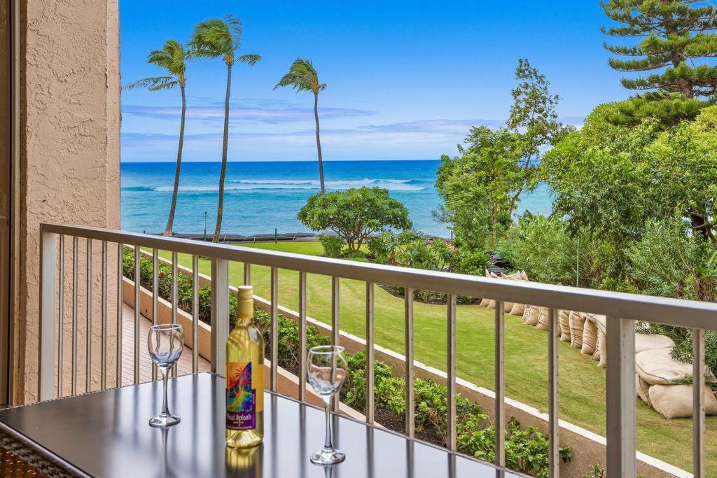 d'un balcon avec une table, des verres à vin et l'océan. dans l'établissement Condos in Royal Kahana, à Kahana
