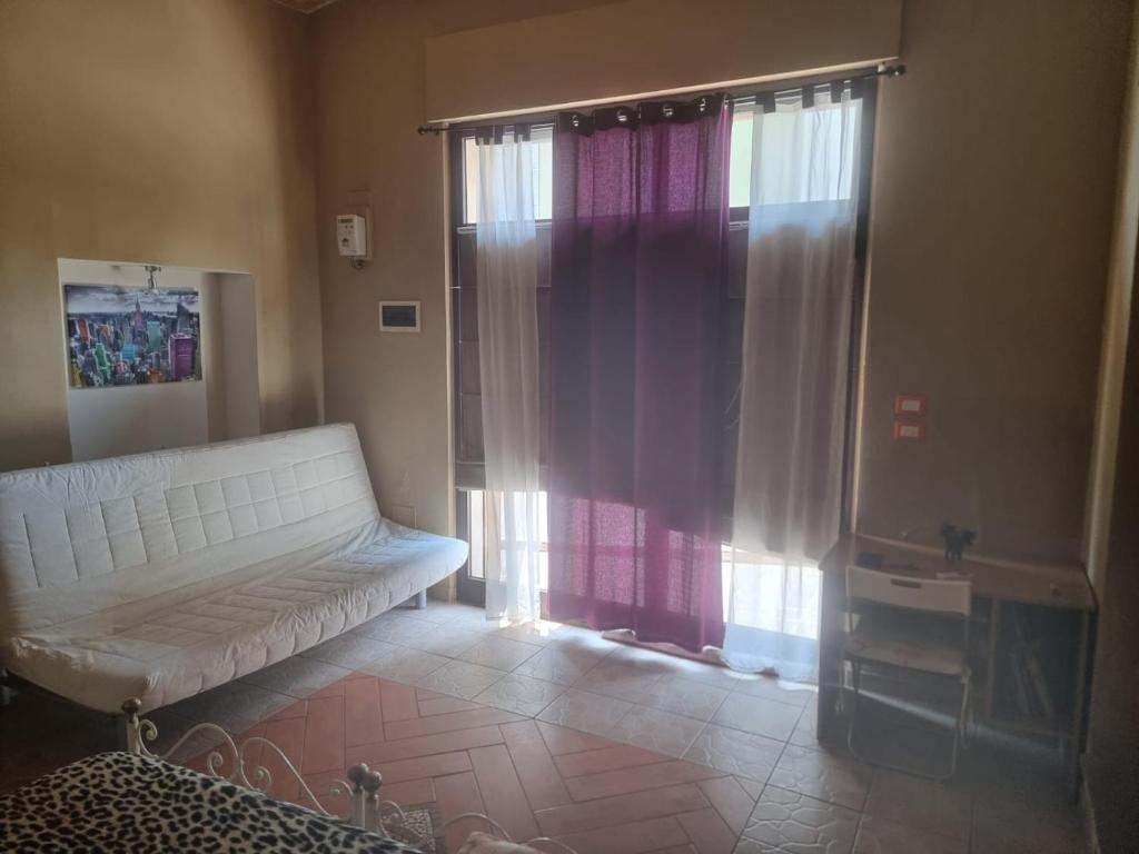 a living room with a white couch and a window at SPELTAUR B&B in Spoltore