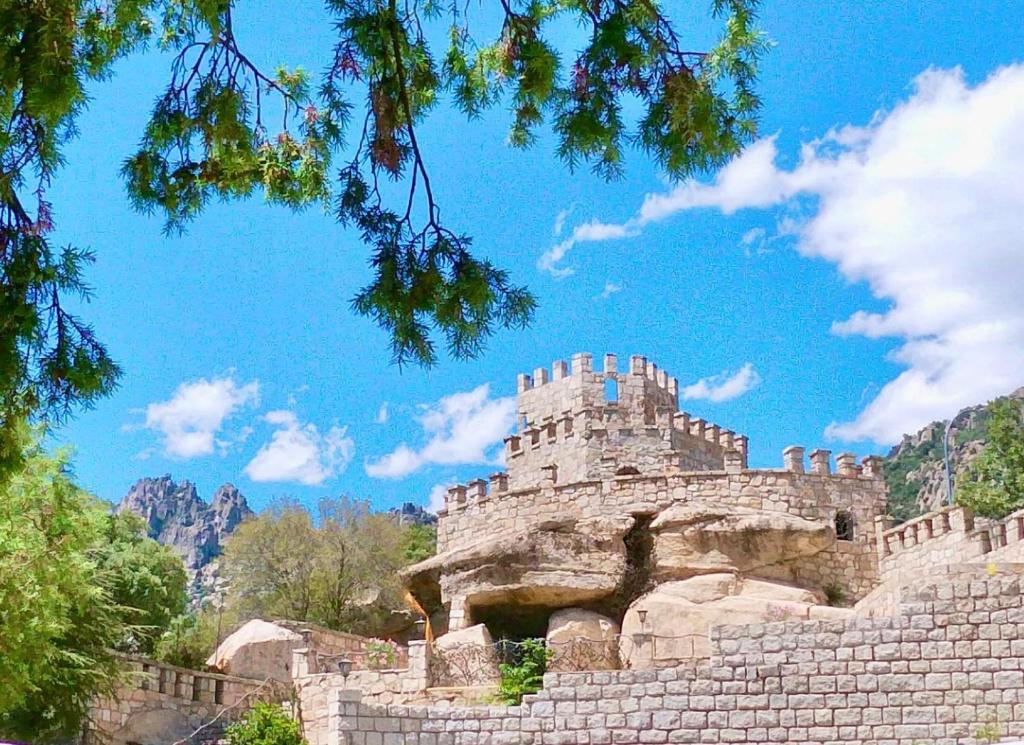 a castle sitting on top of a stone wall at Magnífico Castillo privado, elevado en la roca in La Cabrera