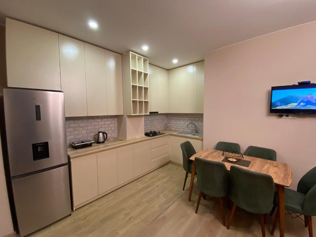 a kitchen with a table and chairs and a refrigerator at Dani Apartment in Kutaisi