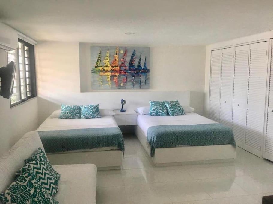 ein Schlafzimmer mit 2 Betten und einem Wandgemälde in der Unterkunft Villa del mar apartaestudio in San Andrés