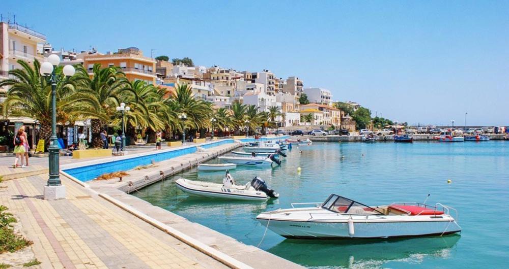 a group of boats docked in a river with buildings at Sofi's Home Project in Sitia