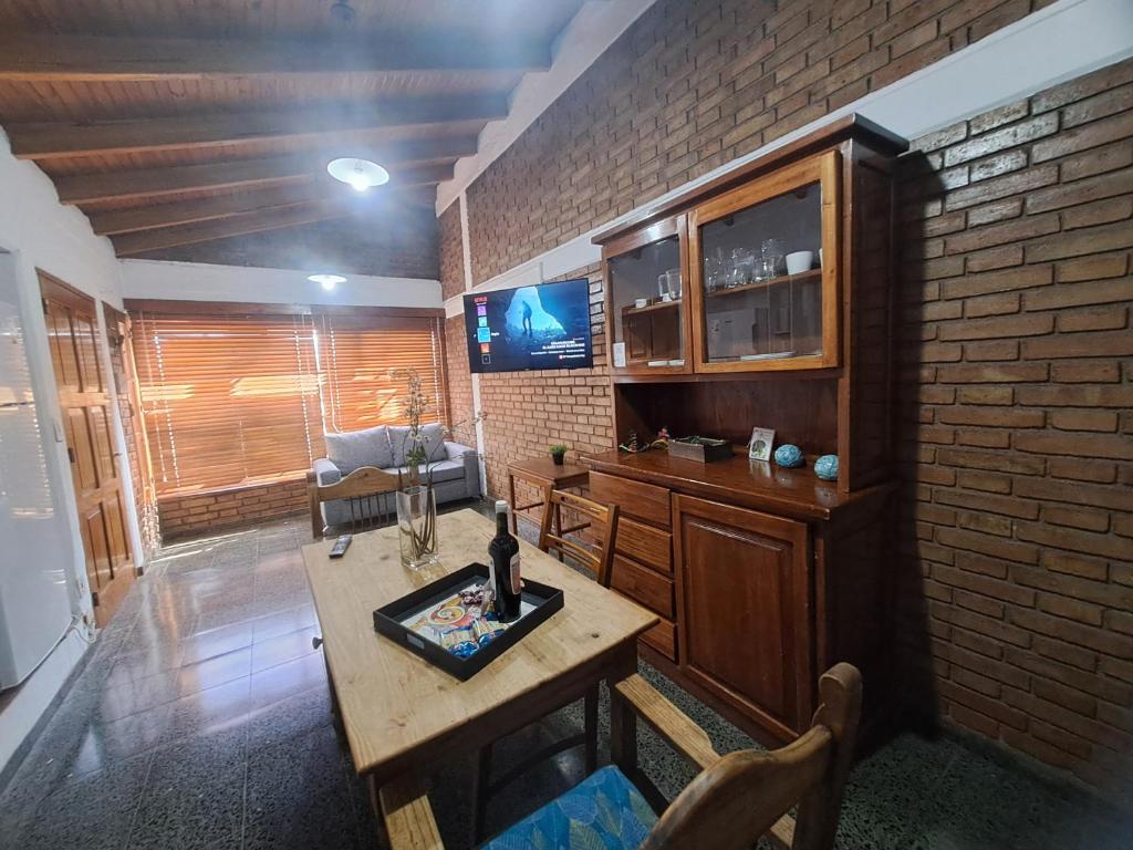 a living room with a table and a brick wall at Mendoza Urbano Confort in Mendoza