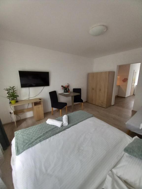 ein Schlafzimmer mit einem großen weißen Bett und einem TV in der Unterkunft Spí v Kuklenách in Hradec Králové