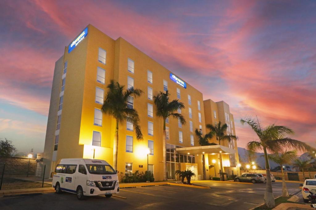 une camionnette blanche garée devant un bâtiment dans l'établissement City Express by Marriott Ciudad Victoria, à Ciudad Victoria