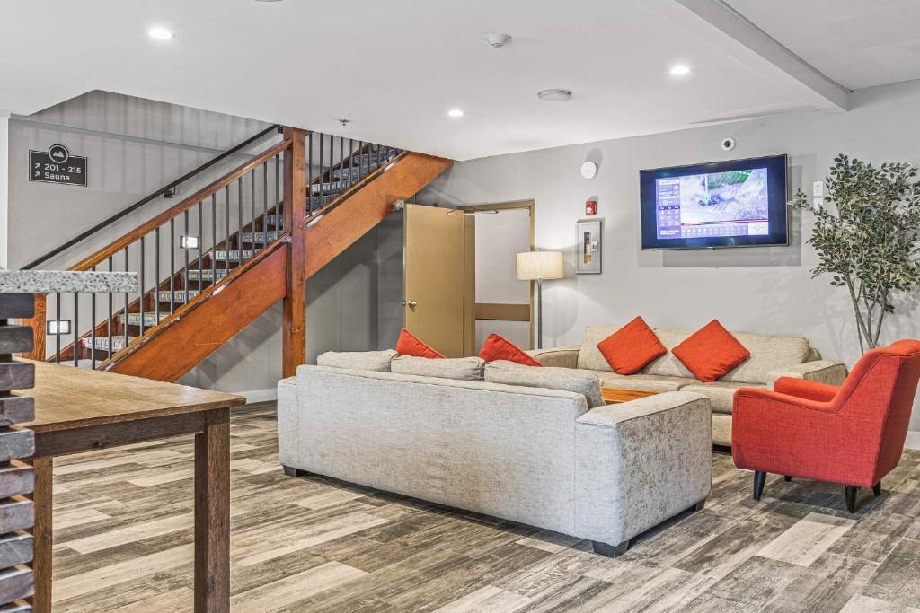 a living room with two couches and a staircase at Basecamp Lodge Canmore in Canmore