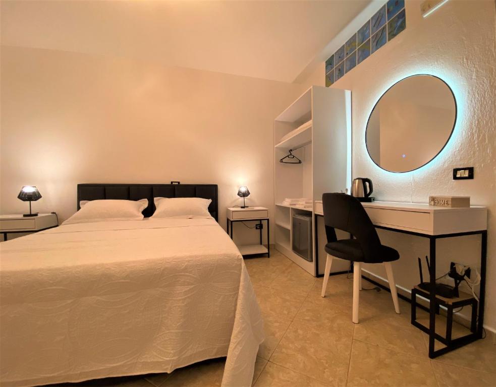 都拉斯The White Corner的卧室里有一张床、一张书桌和一面镜子