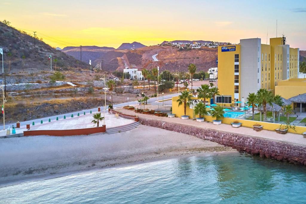 un puente sobre el agua cerca de una playa con edificios en City Express by Marriott La Paz en La Paz