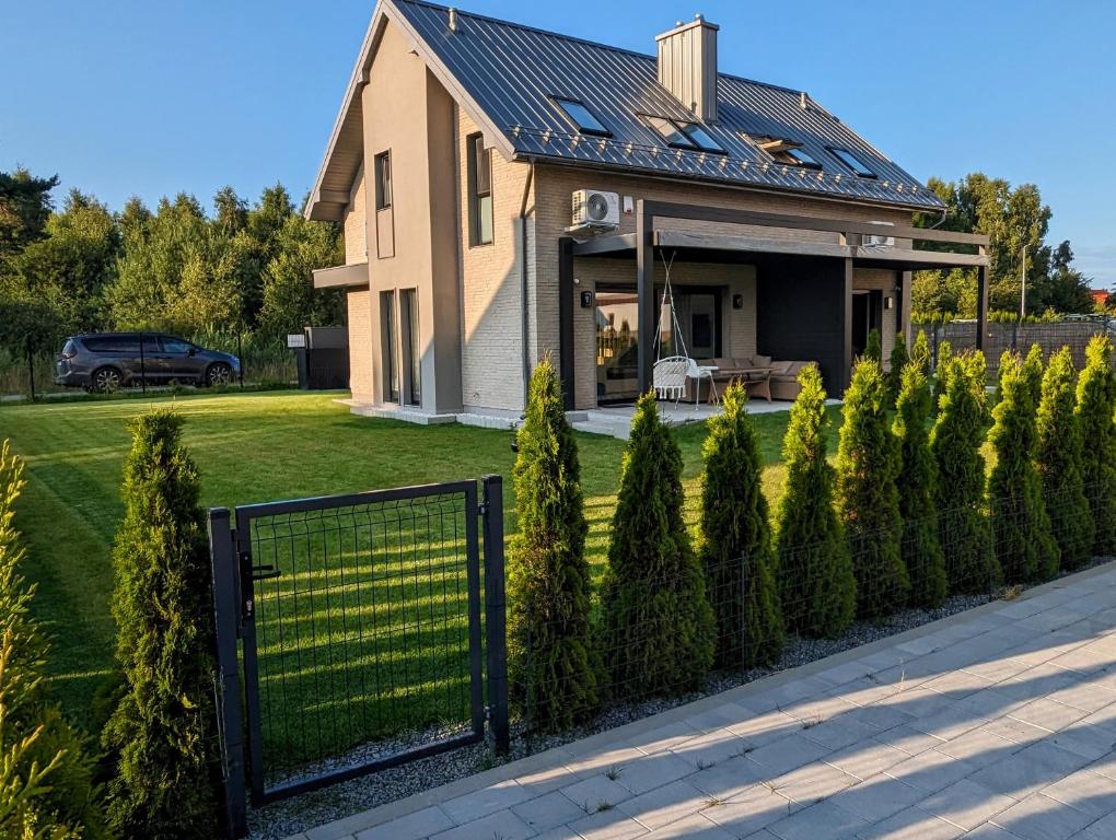 a house with a fence in front of a yard at Błękitna Dębki in Dębki