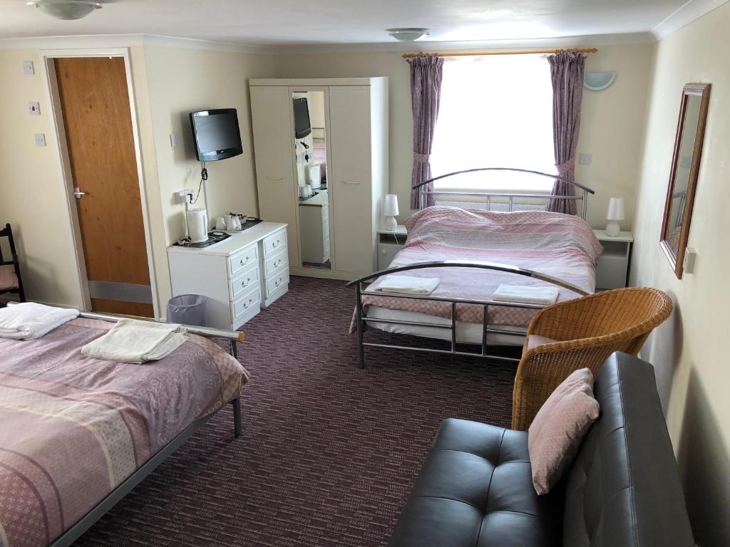 ブラックプールにあるBronte Houseのベッド2台とソファが備わるホテルルームです。
