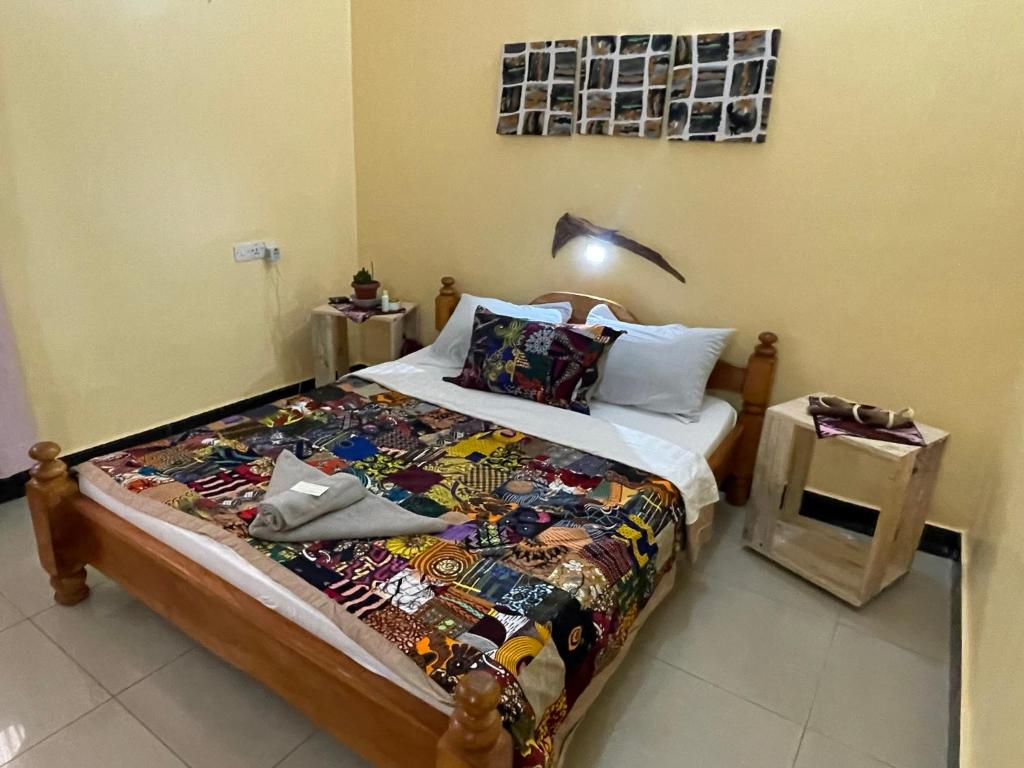 a bedroom with a bed with a quilt on it at Home Feeling Kilimanjaro in Moshi