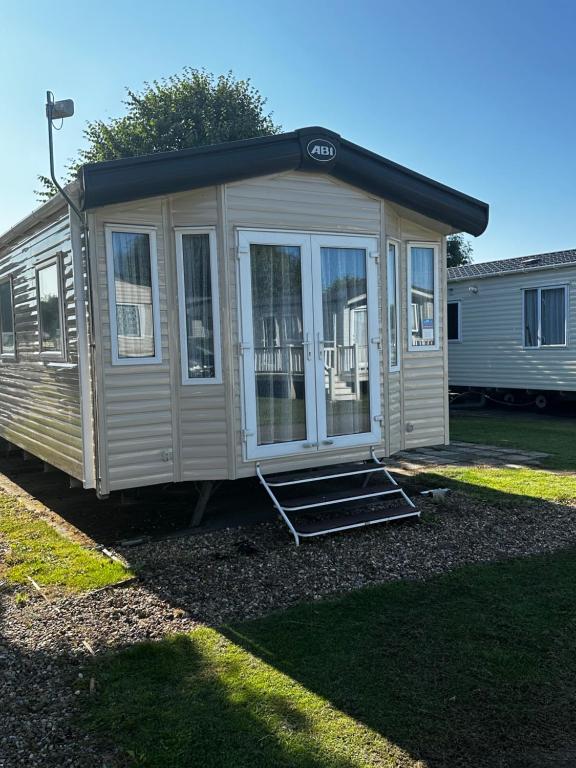 a tiny house is sitting in a yard at Happy Place in West Mersea