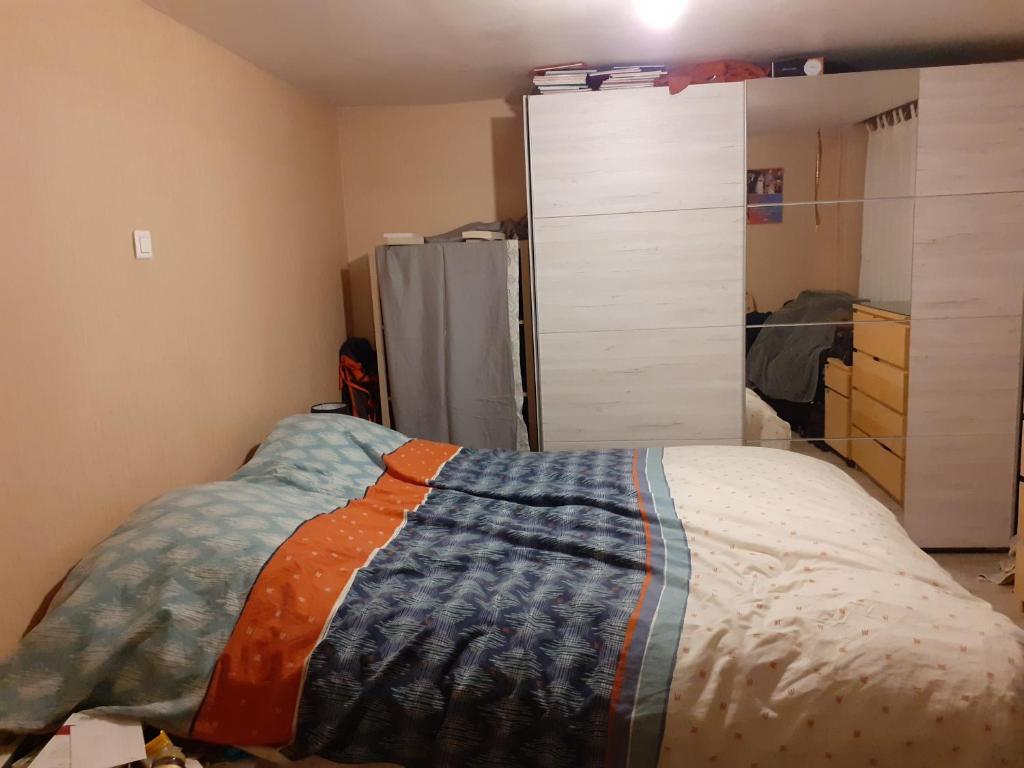 - une chambre avec un lit et un réfrigérateur dans l'établissement bel appartement de 56 m² au calme et de plein pied, à Bust