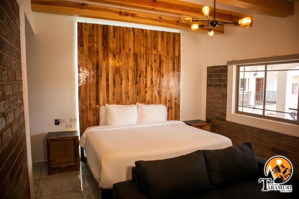 1 dormitorio con cama, ventana y sofá en TARAMURI HOTEL & TOURS en Creel