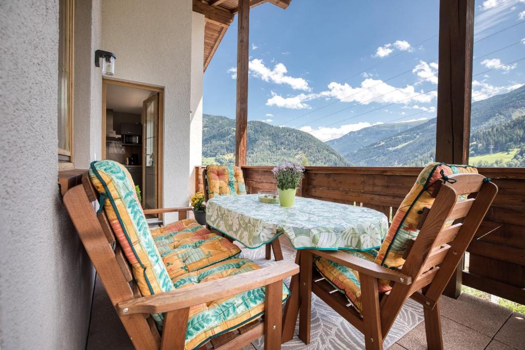 una mesa y sillas en un balcón con vistas en Chill Out Apartments, en Landeck