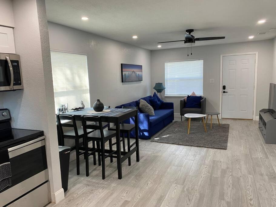 a living room with a blue couch and a table at Charming 2-Bedrooms Central Clearwater Apartment With Private Backyard in Clearwater