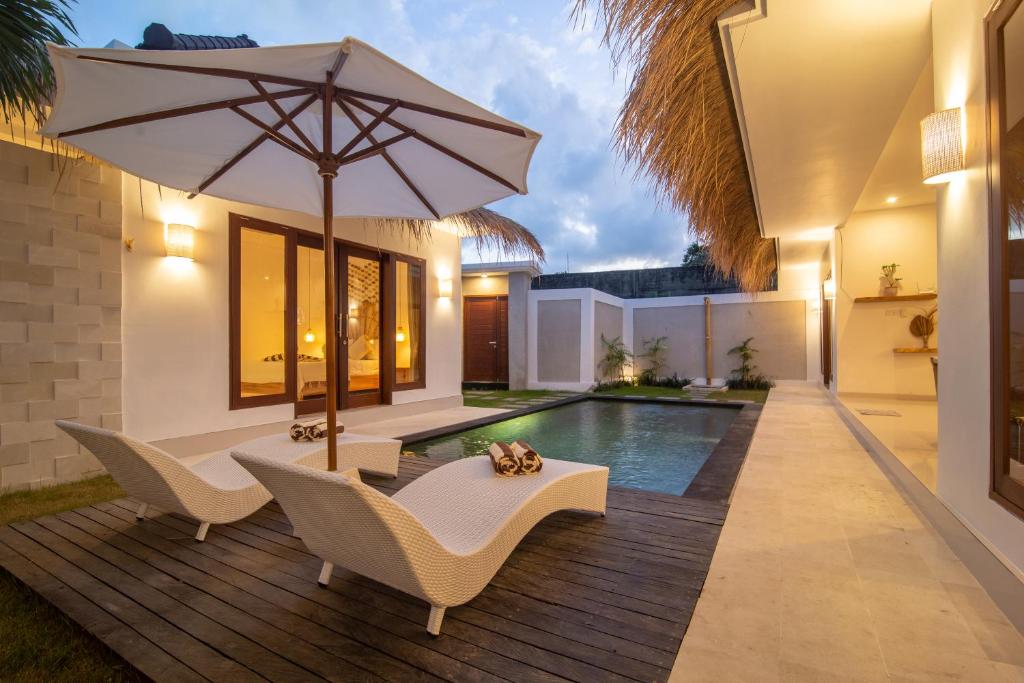 水明漾‎的住宿－Simple & Magical Villas. Villa Sambali llI，一个带遮阳伞和椅子的庭院和一个游泳池