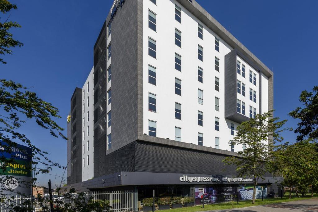 a large white building with a black facade at City Express Plus by Marriott Bogota Aeropuerto in Bogotá