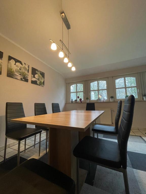 una sala de conferencias con mesa de madera y sillas en Monteurwohnung, en Emsbüren