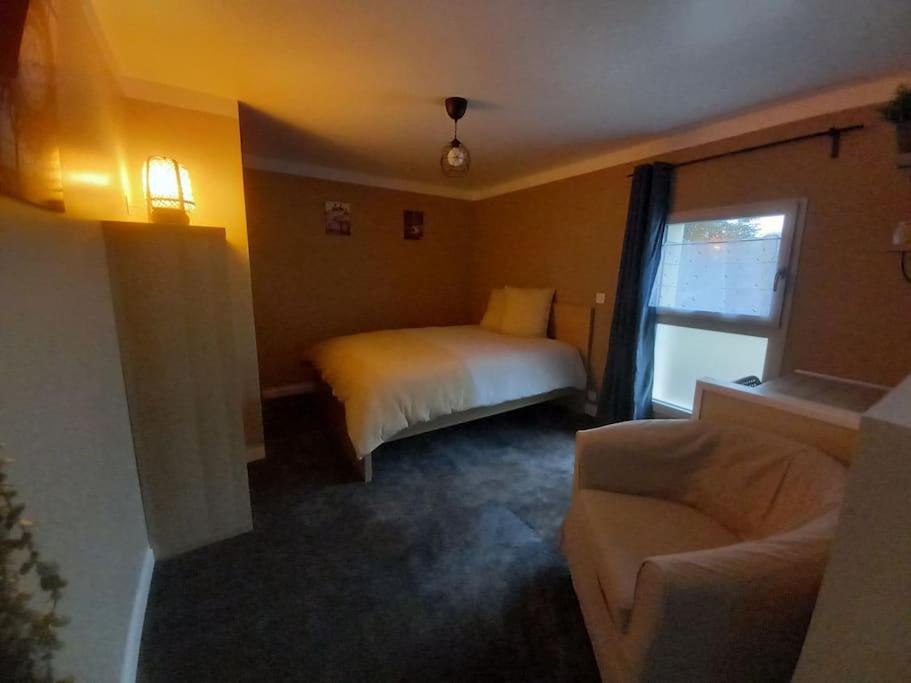 Habitación de hotel con cama y sofá en La Grelauderie 3 en Saintes