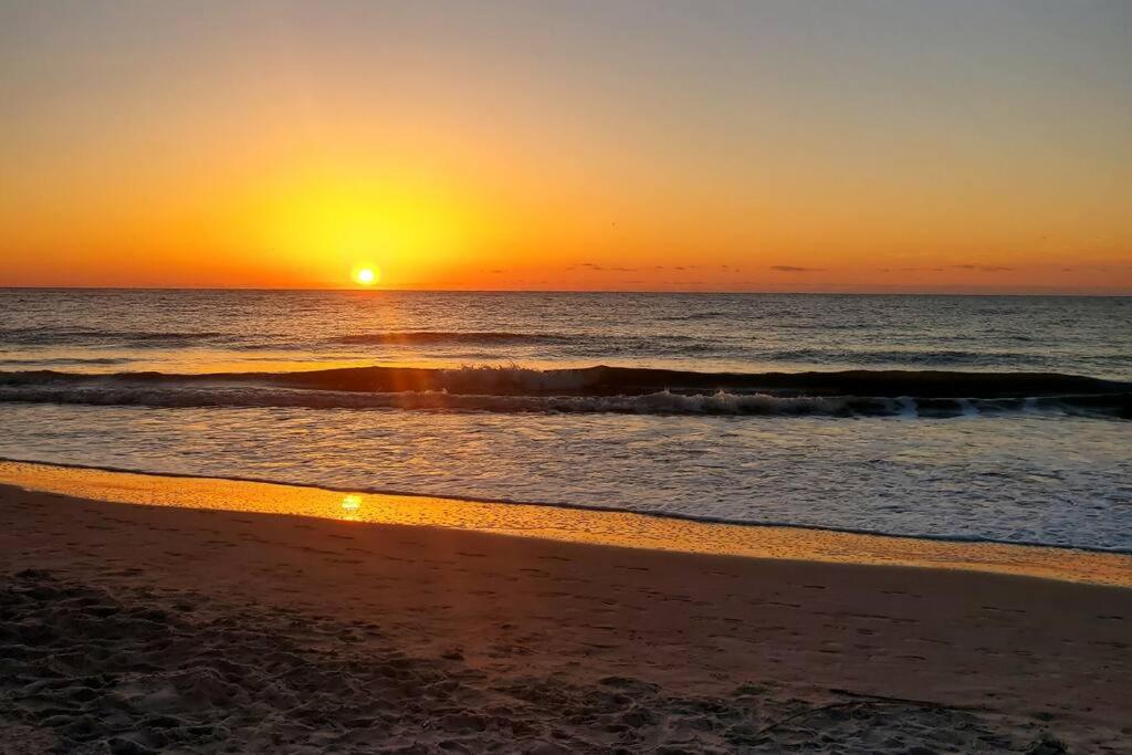una puesta de sol en una playa con el océano en Cute 2 bedroom, 2 bath Condo at Folly Field Beach, en Hilton Head Island