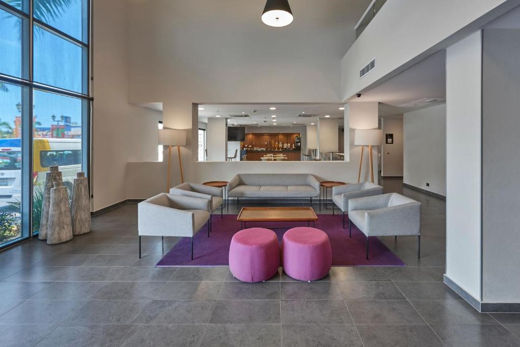 a lobby with a couch and chairs and a table at City Express by Marriott Tampico in Tampico