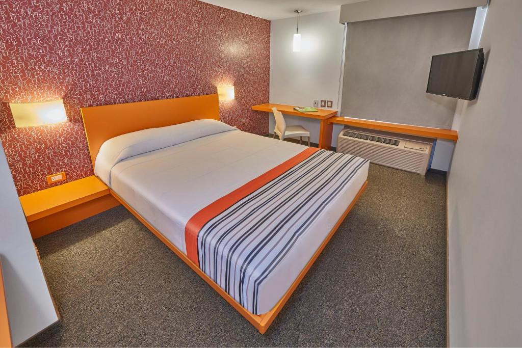 een slaapkamer met een groot bed en een bureau bij City Express Junior by Marriott Tuxtla Gutierrez Poliforum in Tuxtla Gutiérrez