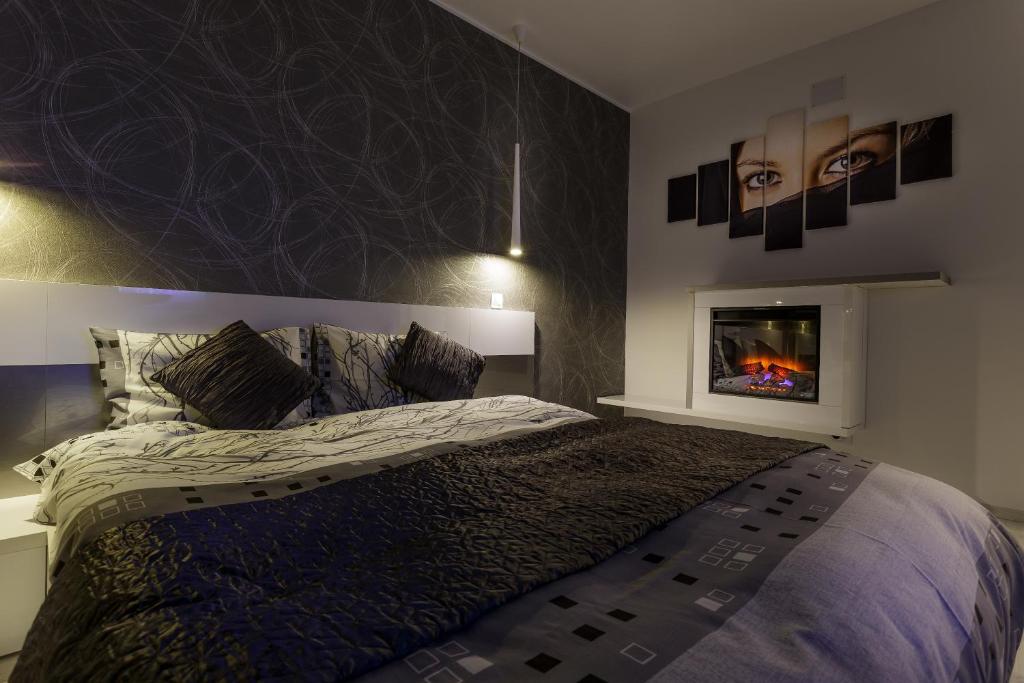 a bedroom with a bed with a fireplace and a tv at Apartament Perla Falezei in Galaţi