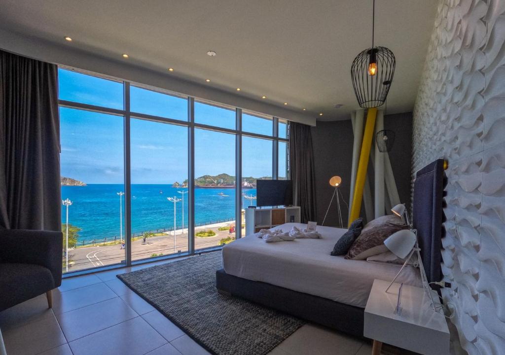 a bedroom with a bed and a view of the ocean at Bonita Bay Concept Hotel by Xarm Hotels in Santa Marta