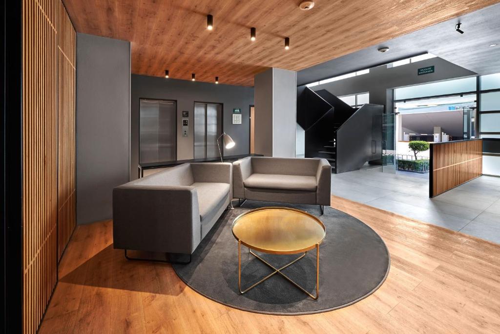 a living room with a couch and a table at City Express by Marriott Ciudad de México EBC Reforma in Mexico City