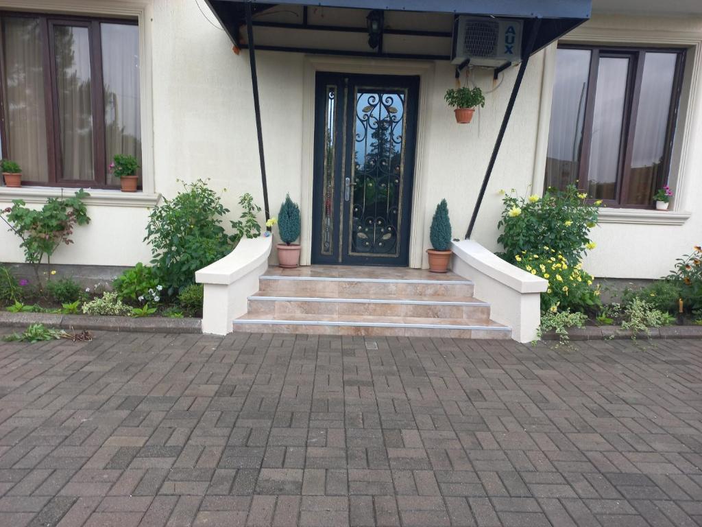 uma porta da frente de uma casa com vasos de plantas em Mate's GUEST HOUSE em Kobuleti