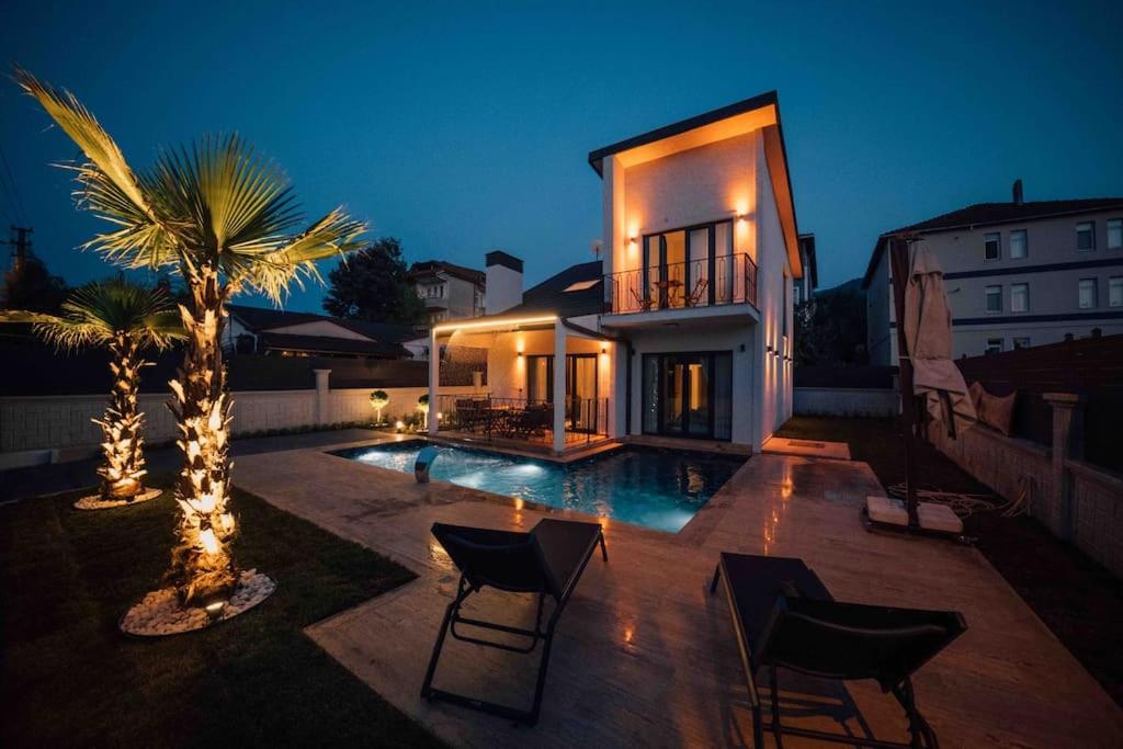 une maison avec un palmier et une piscine dans l'établissement Villa Karam, à Kocaeli