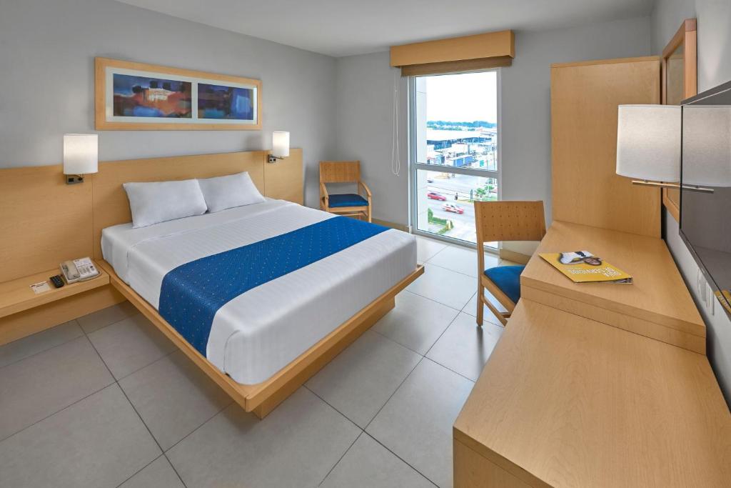 une chambre d'hôtel avec un lit et une télévision dans l'établissement City Express by Marriott Minatitlán, à Minatitlán