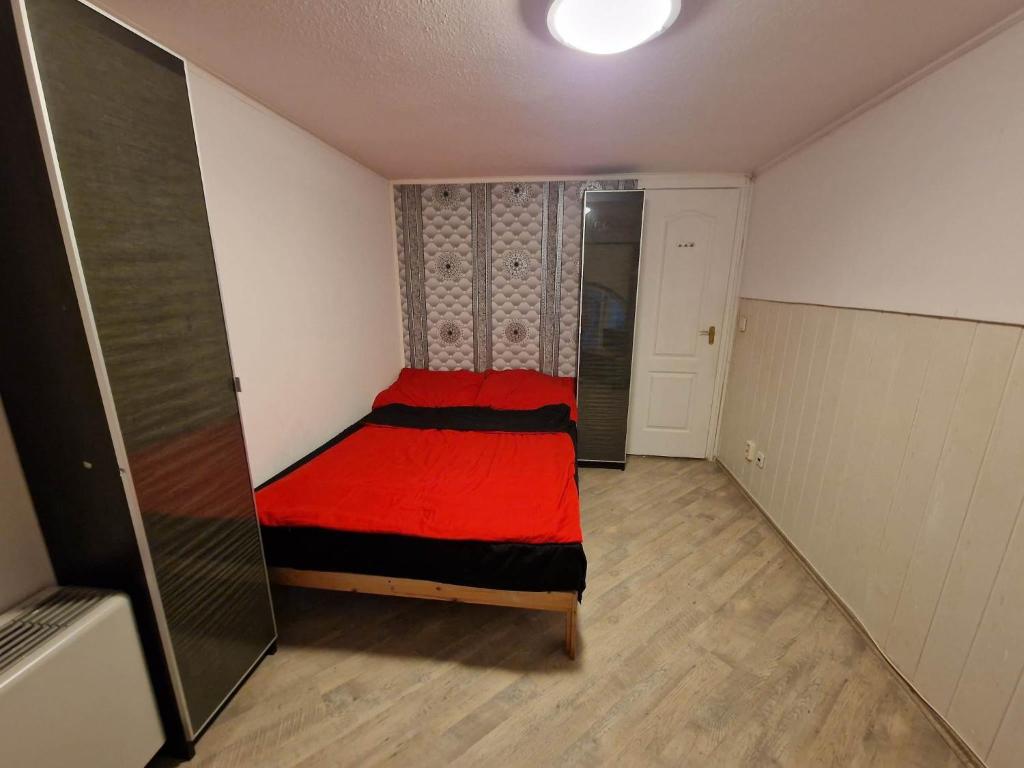 a small bedroom with a red bed in it at 7DAB 0-9 contactless self check-in in Budapest