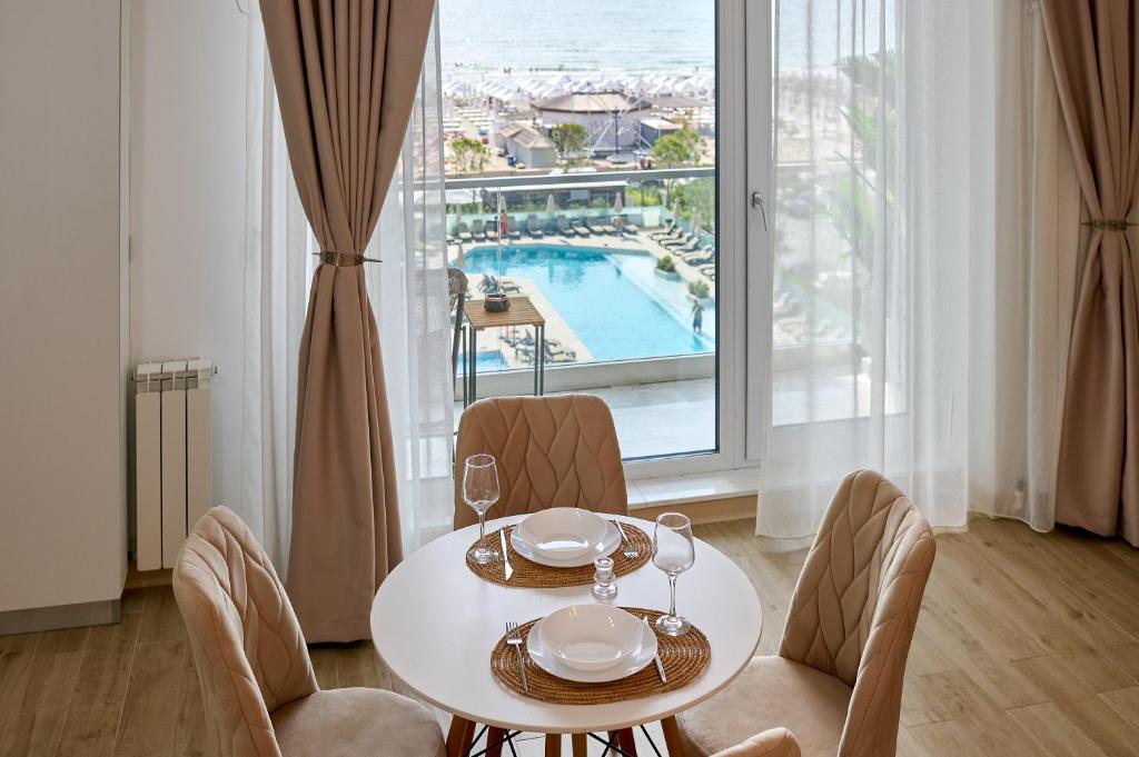 a dining room with a table and chairs and a window at TGM Sunrise View in Infinity Pool & Spa Resort in Mamaia Sat/Năvodari