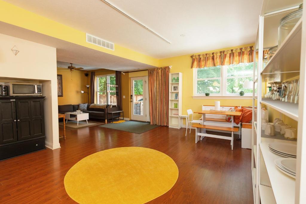 a living room with yellow walls and a yellow rug at Home STEPS from Oberlin in Oberlin