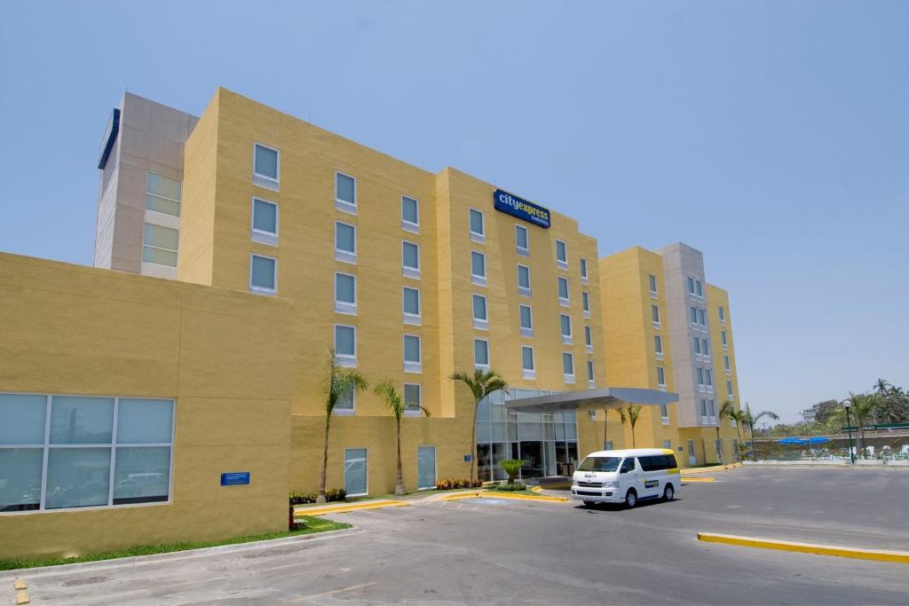 una furgoneta blanca estacionada frente a un hotel en City Express by Marriott Lazaro Cardenas, en Lázaro Cárdenas