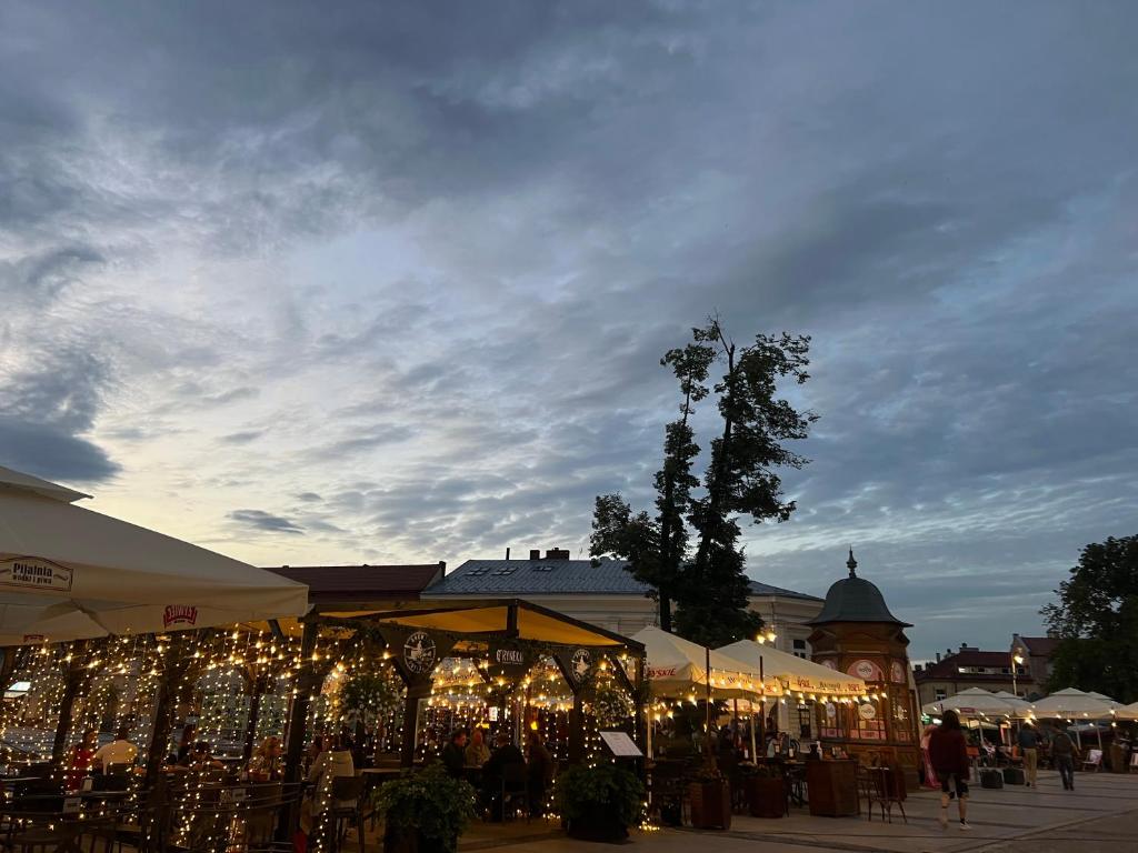 a lit up market with christmas lights on display at Family & Business Sauna Apartments Sienkiewicza Wesoła No 5 Centrum Downtown - 2 Bedroom with Private Sauna, Bath with Hydromassage, Parking - NEW! in Kielce